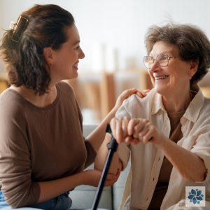 image of a female putting hand on shoulder of an older female, both smiling. For the blog How Can a Patient Advocate Help Me?